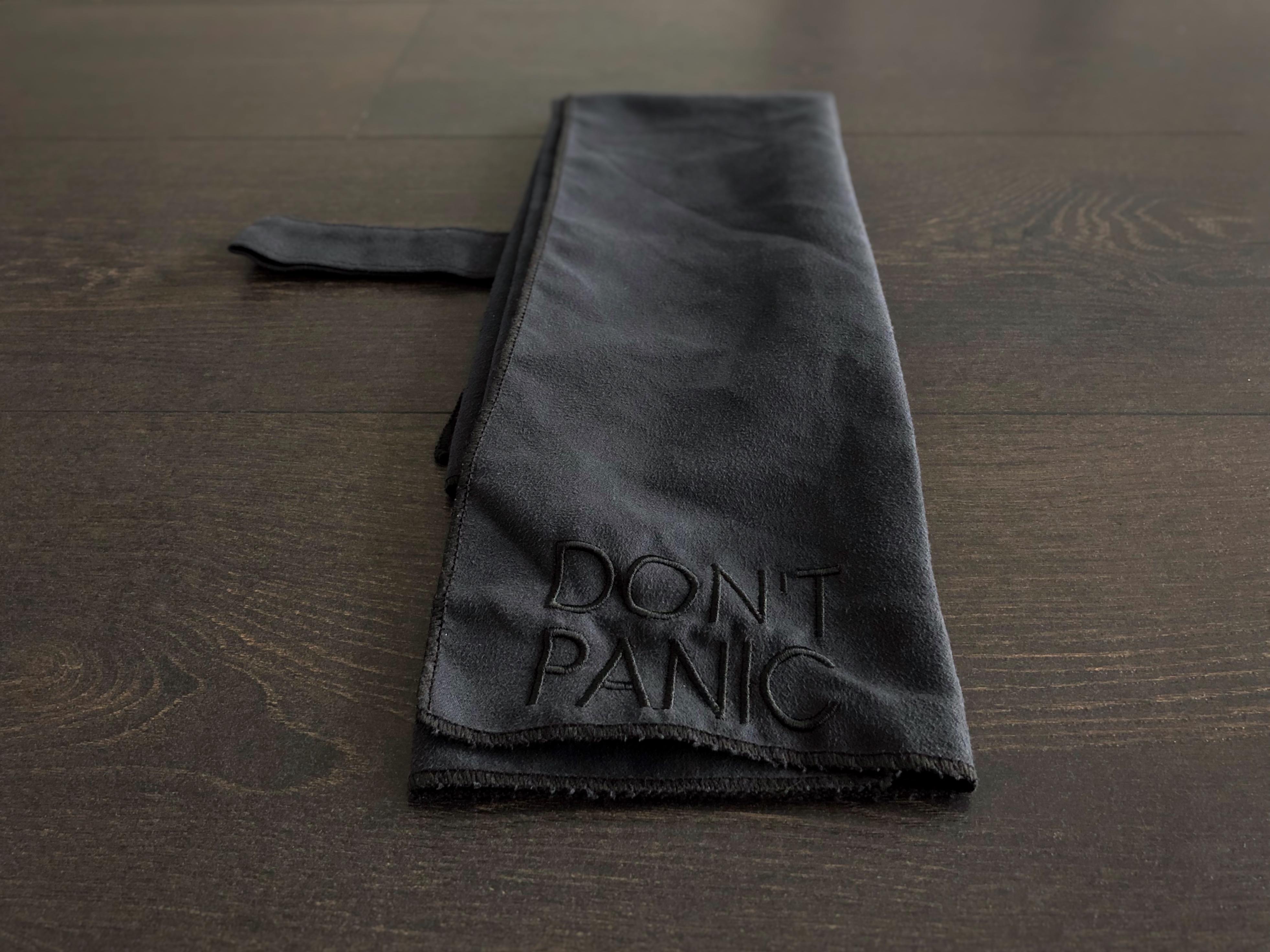 A microfiber towel embroidered with the words &ldquo;Don&rsquo;t Panic&rdquo;